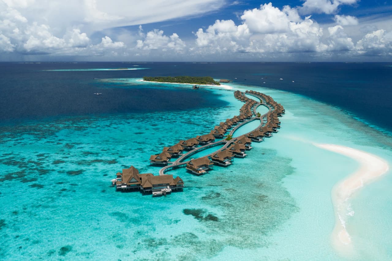 Overwater villas beside the island sandbank, aerial view at Joali Maldives