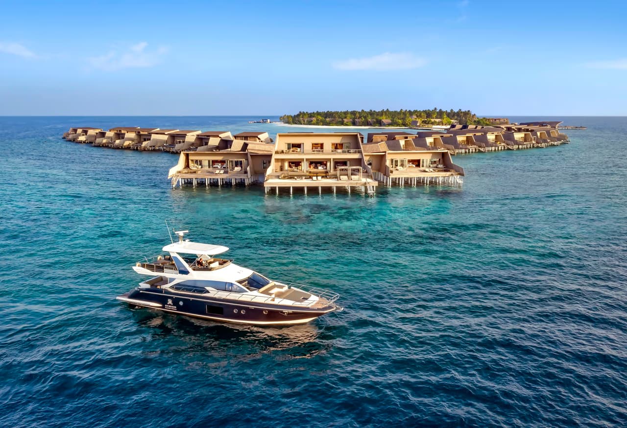 Yacht in front of overwater villas at The St. Regis Maldives Vommuli Resort