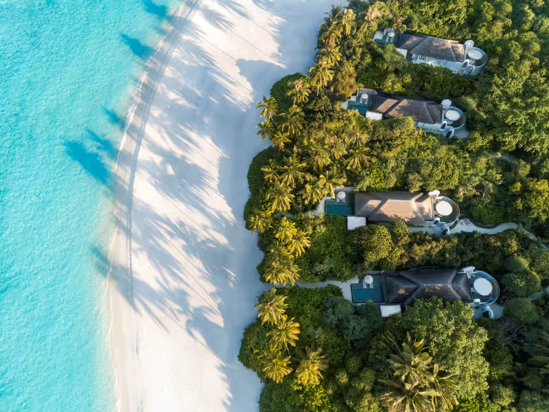 Beach villas beside the white sand beach, aerial view at Anantara Kihavah