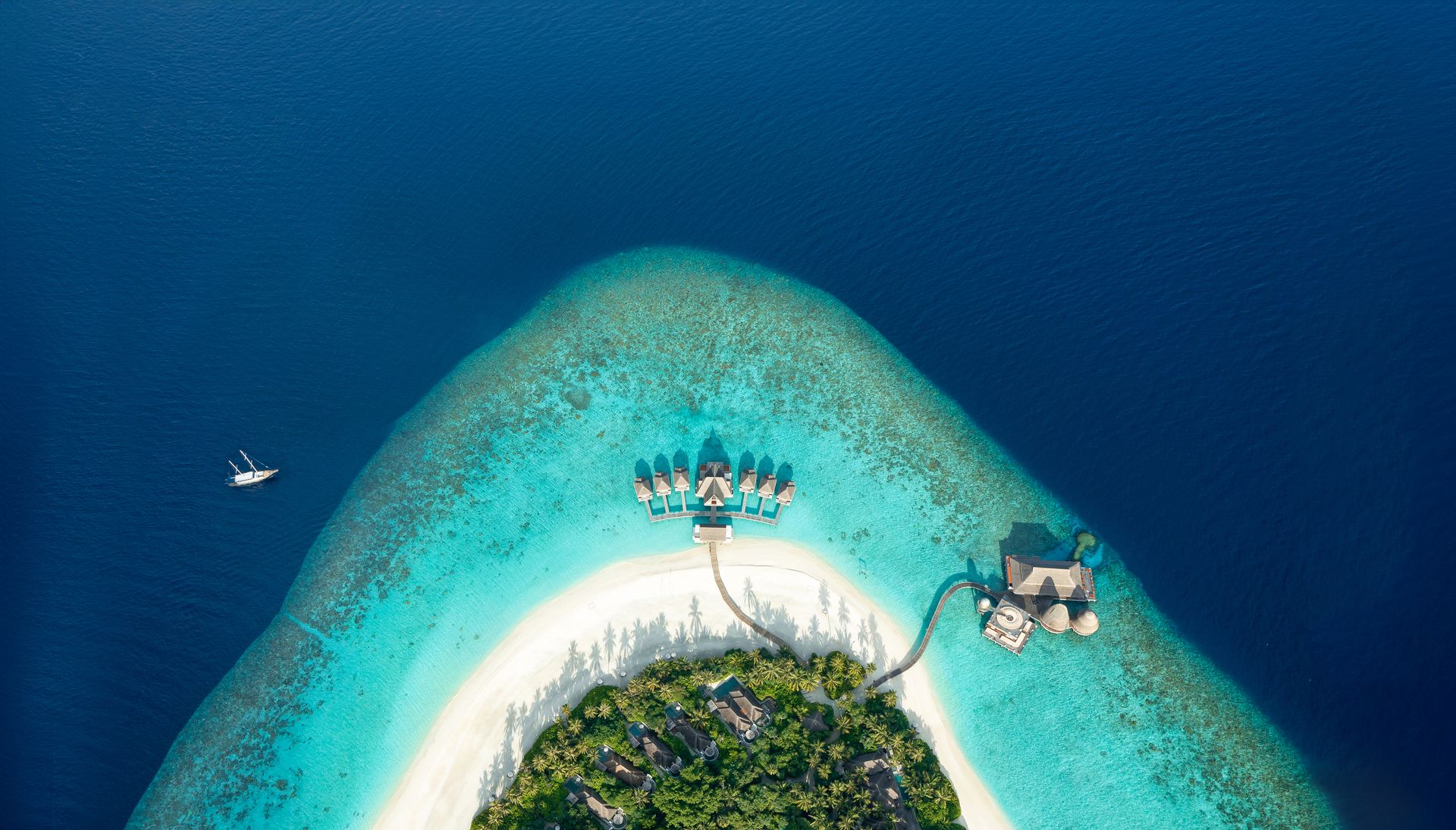 Island tip surrounded by coral reef, aerial view at Anantara Kihavah
