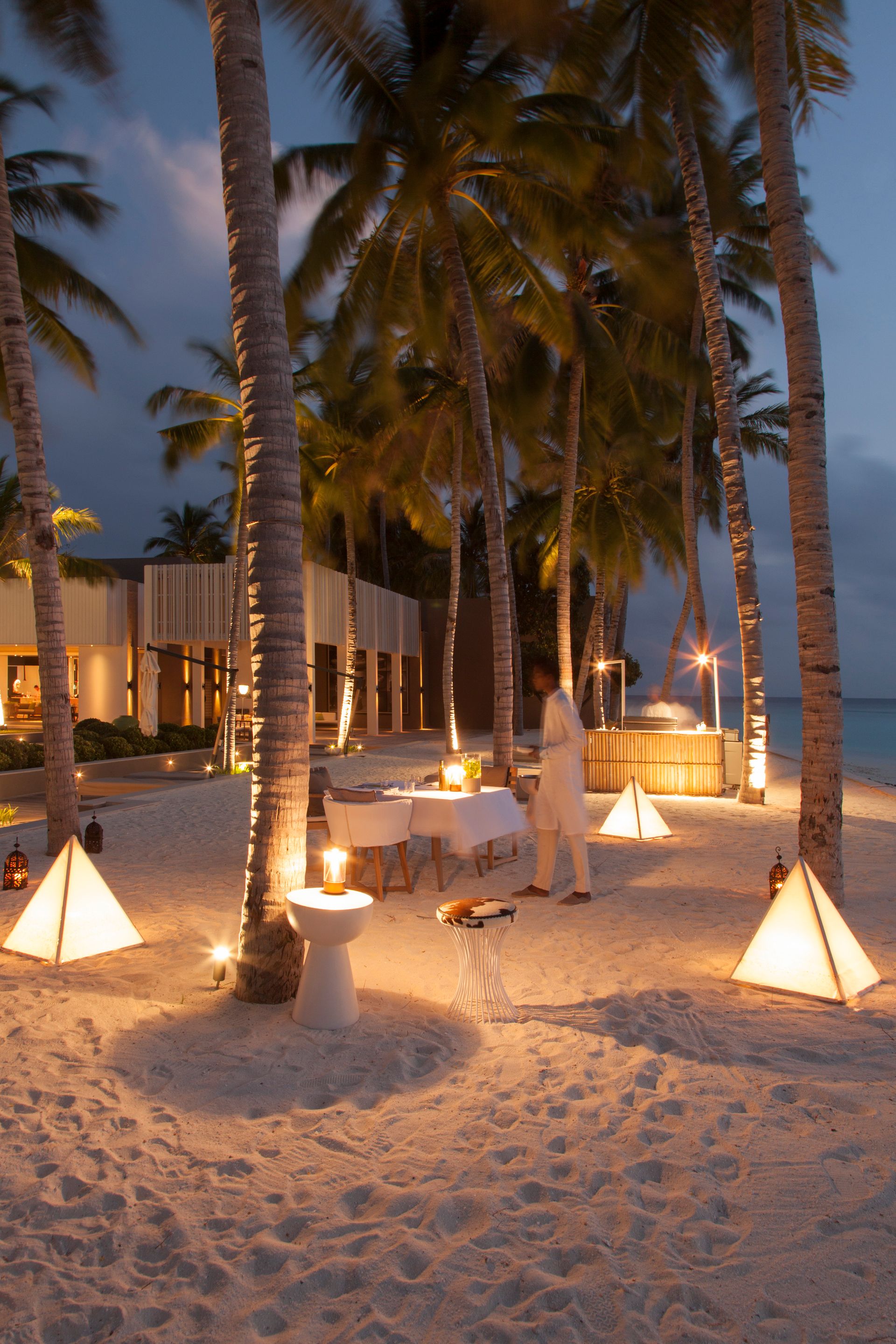 Candlelit beach dining beneath palm trees at Cheval Blanc Randheli