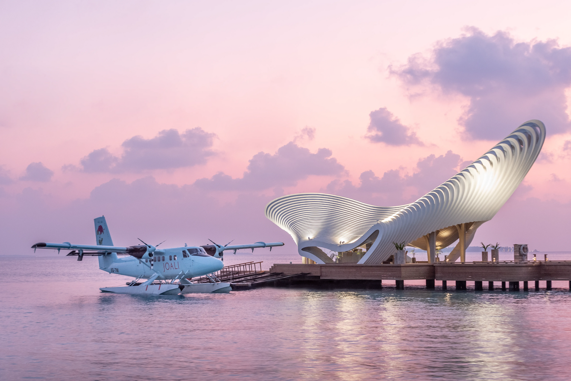 Seaplane beside the arrival jetty at sunset at Joali Being
