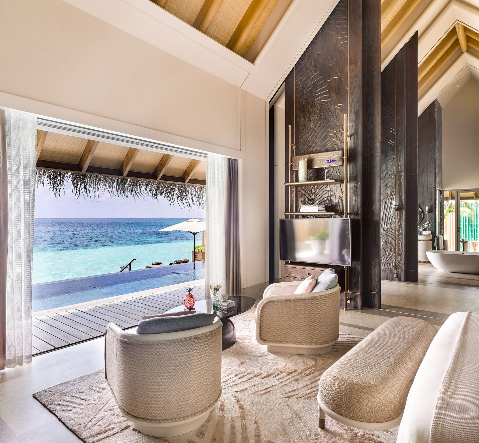 Water villa bedroom seating area at Joali Maldives