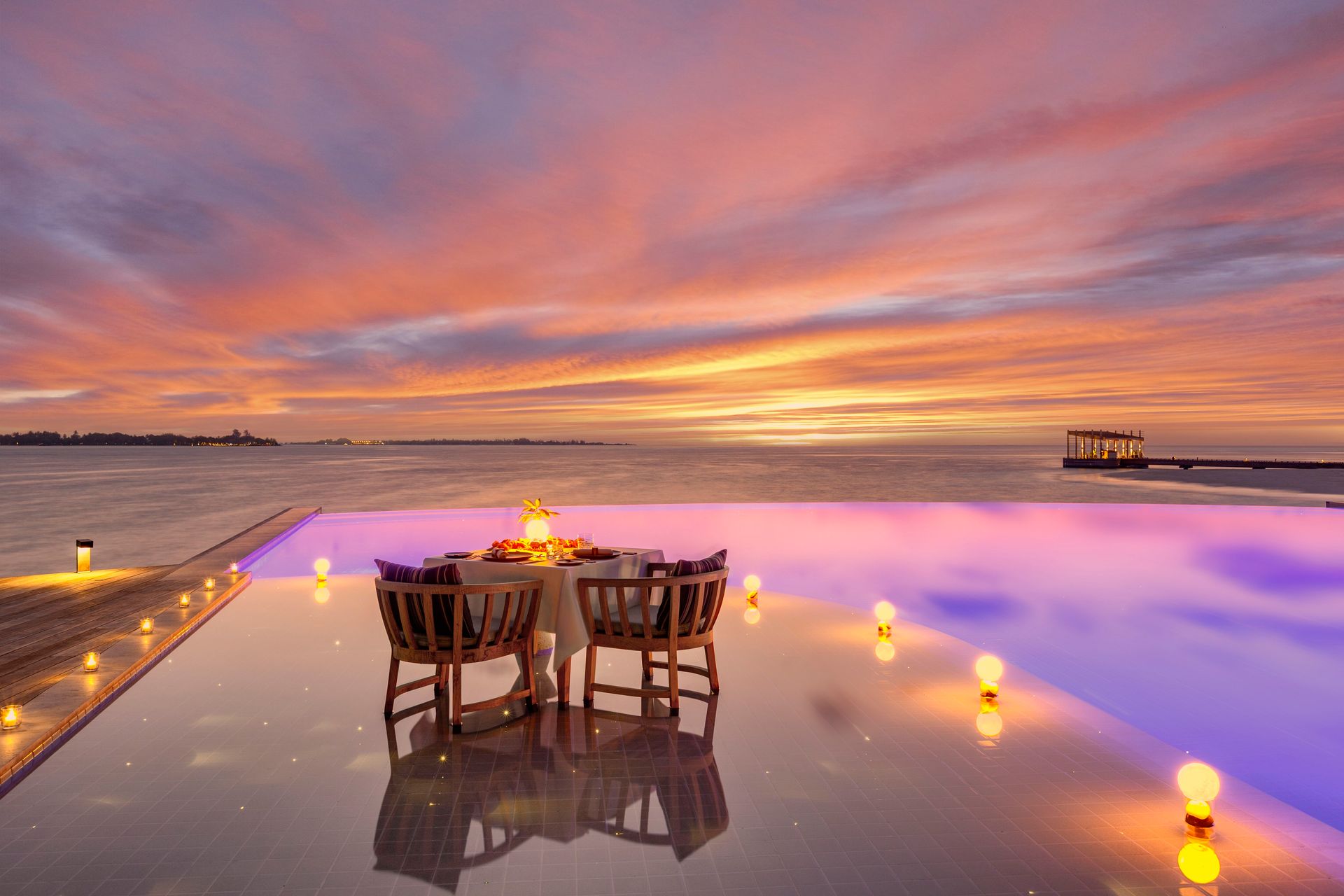 Private dining beside the pool at sunset at Kudadoo Private Island