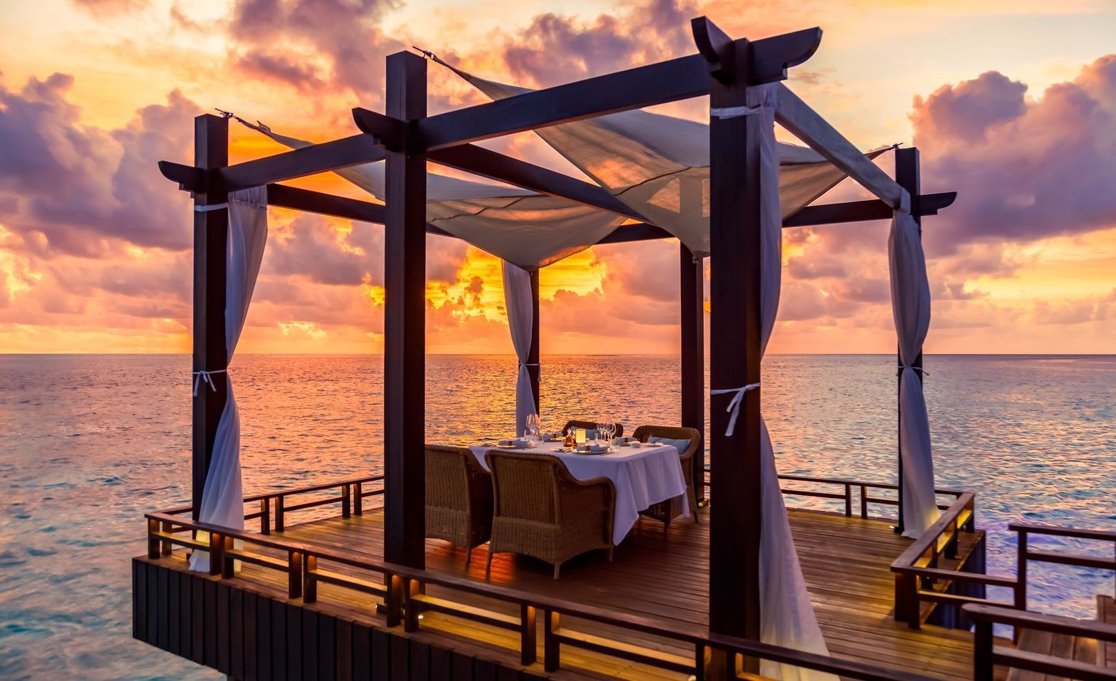 Private dining pavilion at sunset at Ozen Reserve Bolifushi