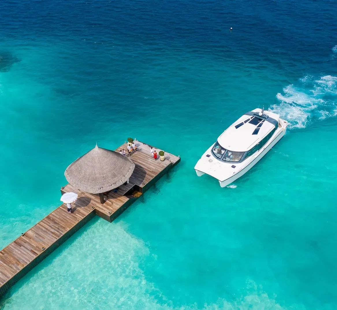 Yacht beside an overwater arrival jetty at Ozen Reserve Bolifushi