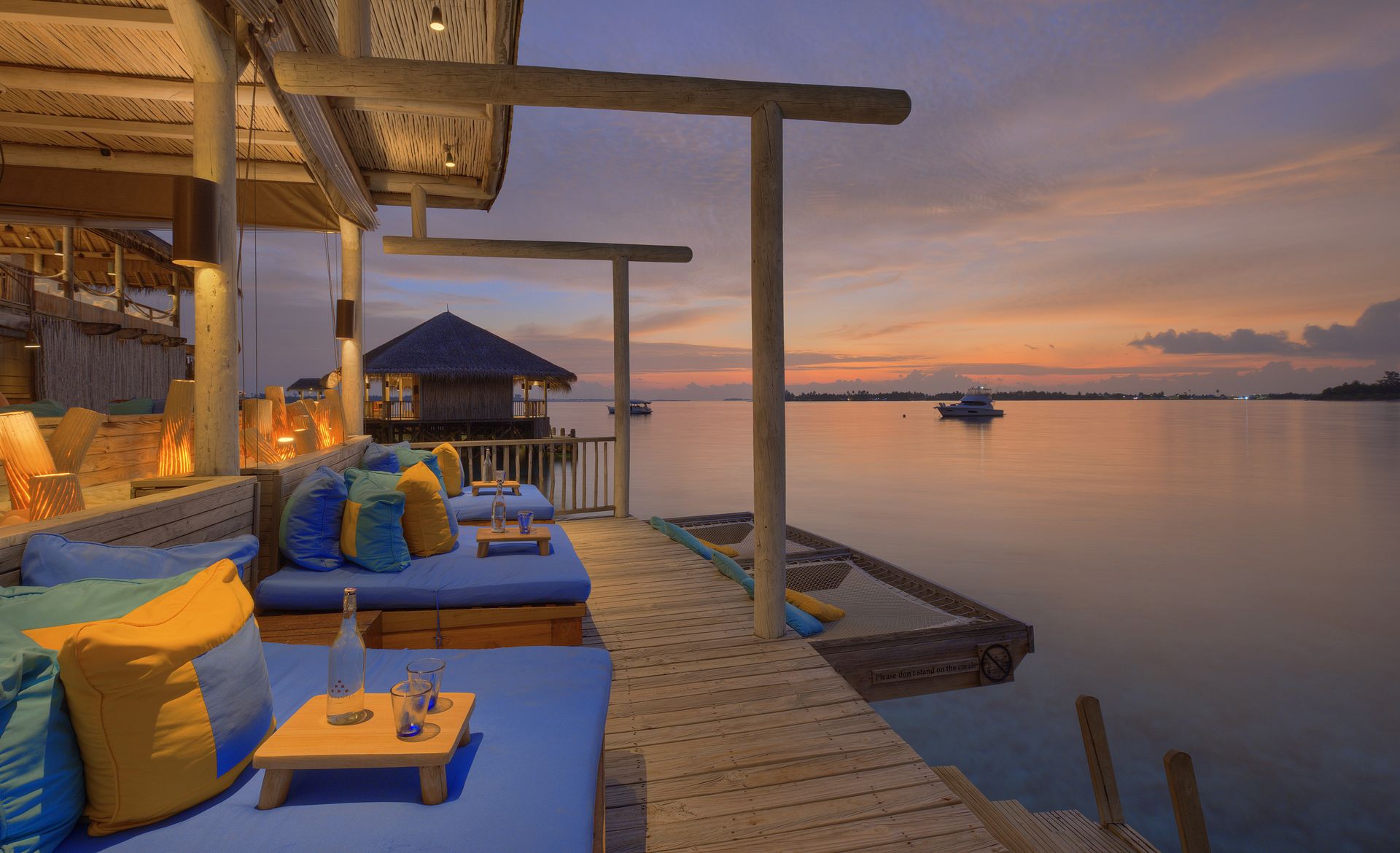 Overwater lounge at sunset at Six Senses Laamu