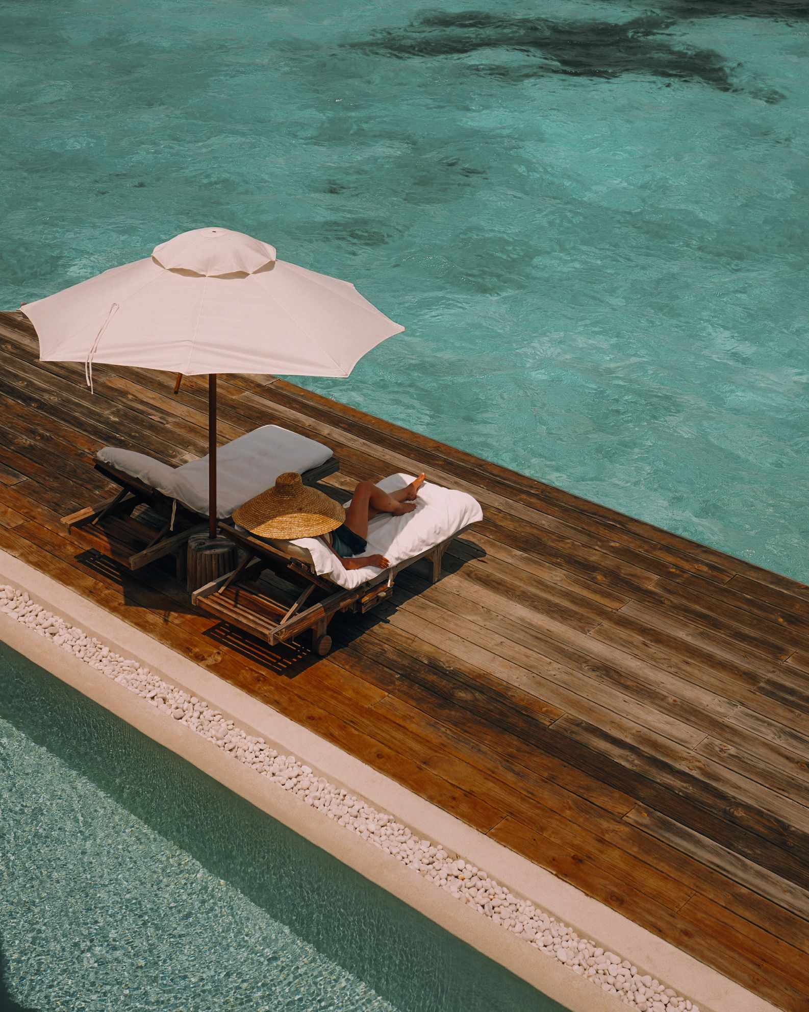 Loungers on an overwater sun deck at Soneva Jani
