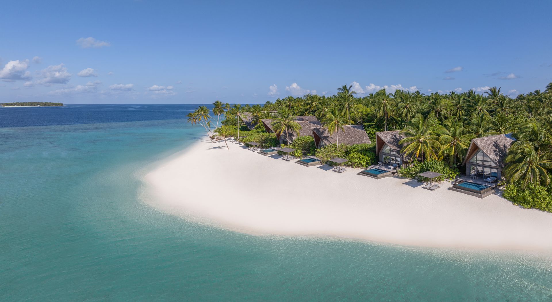 Beach villas and white sand shoreline at The St. Regis Maldives Vommuli Resort